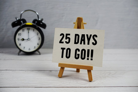 25 Days To Go! text with easel and alarm clock on wooden backgroundの写真素材