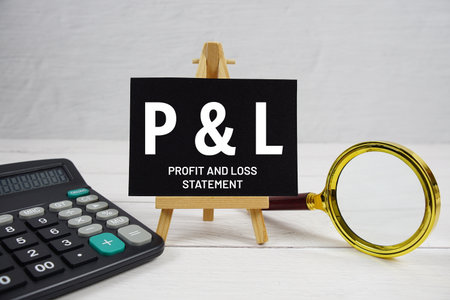 P and L abbreviation of Profit And Loss Statement text with magnifying glass and calculator on wooden backgroundの写真素材