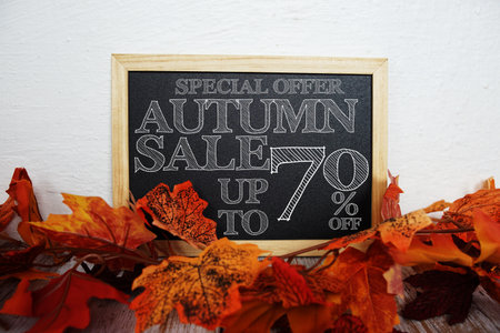 Autumn Sale 70% off text with maple leaf decoration on wooden backgroundの写真素材