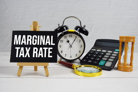 Marginal Tax Rate text with magnifying glass and calculator on wooden backgroundの写真素材