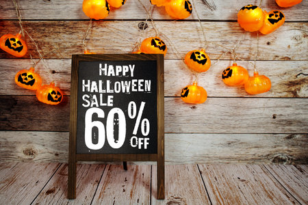 Halloween Sale 60% off text with LED pumpkin decoration on wooden backgroundの写真素材