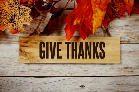 Give Thanks text with maple leaf decoration on wooden backgroundの写真素材