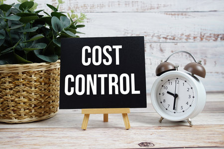 Cost Control text with alarm clock on wooden backgroundの写真素材