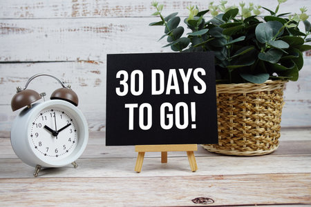 30 Days To Go! text with alarm clock on wooden backgroundの写真素材