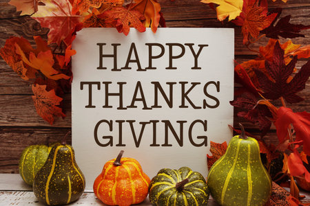Happy Thanksgiving text with maple leaf decoration on wooden backgroundの写真素材