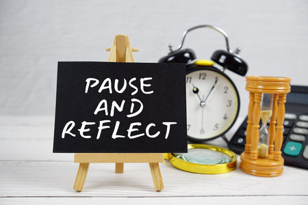 Pause And Reflect text with magnifying glass and calculator on wooden backgroundの写真素材
