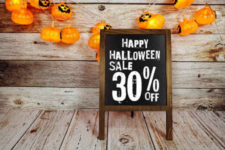 Halloween Sale 30% off text with LED pumpkin decoration on wooden backgroundの写真素材