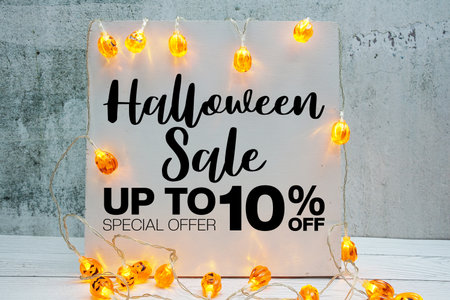Halloween Sale 10% off text with LED pumpkin decoration on wooden backgroundの写真素材