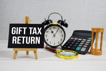 Gift Tax Return text with magnifying glass and calculator on wooden backgroundの写真素材
