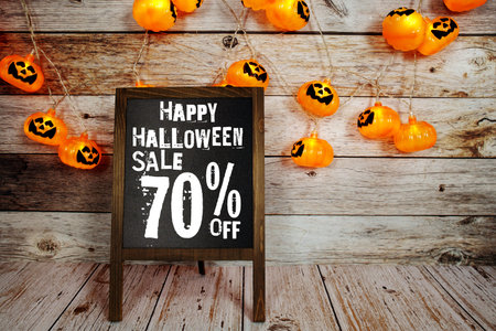 Halloween Sale 70% off text with LED pumpkin decoration on wooden backgroundの写真素材