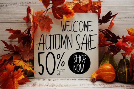 Autumn Sale 50% off text with maple leaf decoration on wooden backgroundの写真素材