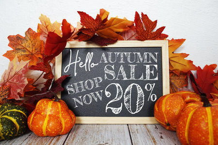 Autumn Sale 20% off text with maple leaf decoration on wooden backgroundの写真素材