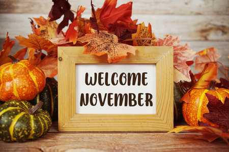 Welcome November text with maple leaf decoration on wooden backgroundの写真素材