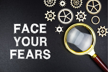 Face Your Fears text message with magnifying glass on black backgroundの写真素材