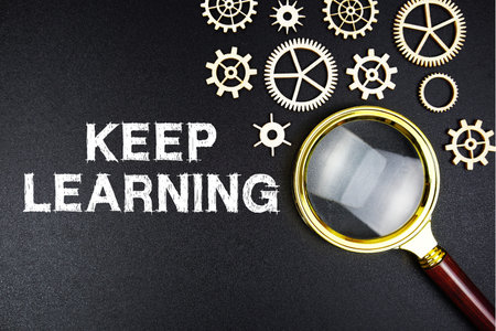 Keep Learning text message with magnifying glass on black background