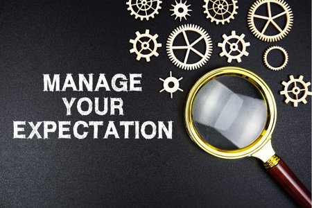 Manage Your Expectations text message with magnifying glass on black background