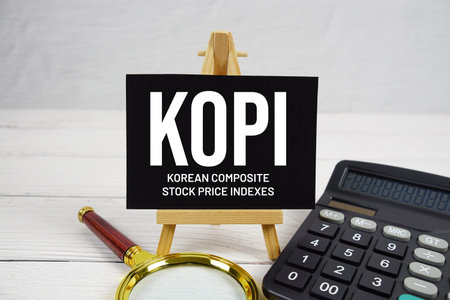 KOPI Korean Composite Stock Price Indexed text with magnifying glass and calculator on wooden backgroundの写真素材