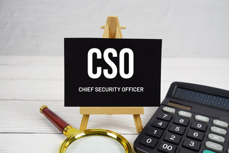 CSO Chief Security Officer text with magnifying glass and calculator on wooden backgroundの写真素材