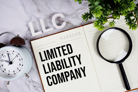 LLC - Limited Liability Company acronym on notepad, Business concept background