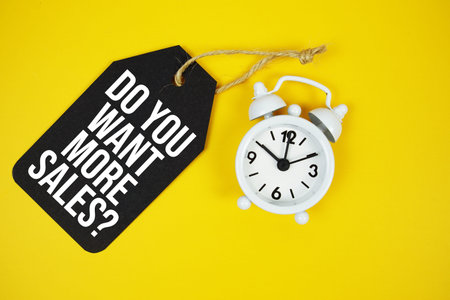 Do you want more sales? text on price tag with alarm clock on yellow background