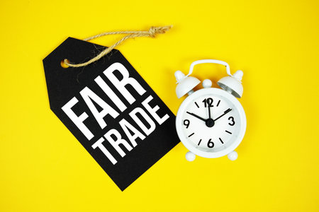 Fair Trade text on price tag with alarm clock on yellow backgroundの写真素材