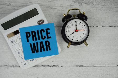 Price War text with calculator and alarm clock  on wooden backgroundの写真素材