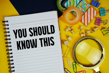You Should Know This text with magnifying glass and stationery on yellow backgroundの写真素材