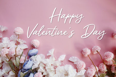 Happy Valentine's Day text with flowers decorations on pink backgroundの写真素材