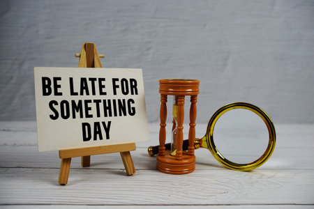 Be Late For Something Day text with hourglass and magnifying glass on wooden background