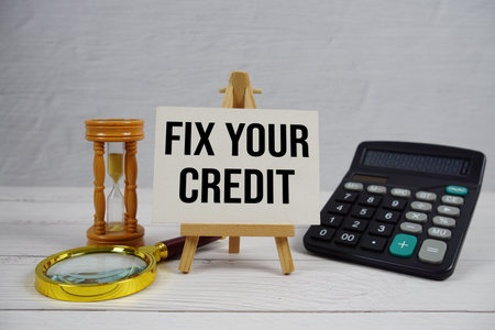Fix Your Credit text with magnifying glass and calculator on wooden backgroundの写真素材