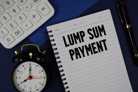 Lump Sum Payment text written on notepad with calculator and alarm clock on navy blue backgroundの写真素材