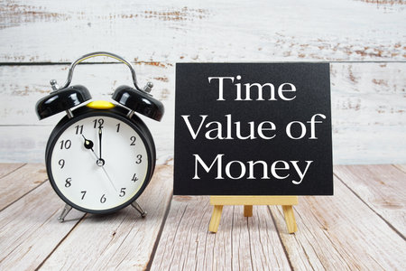 Time Value of Money text with easel and alarm clock on wooden backgroundの写真素材