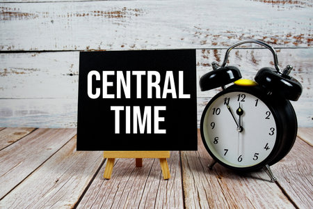 Central Time text with easel and alarm clock on wooden backgroundの写真素材
