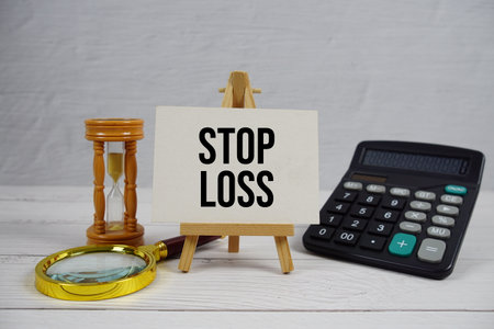 Stop Loss text with magnifying glass and calculator on wooden backgroundの写真素材