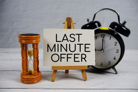 Last Minute Offer text with hourglass and alarm clock on wooden backgroundの写真素材