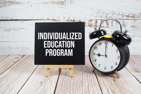 Individualized Education Program text with easel and alarm clock on wooden backgroundの写真素材