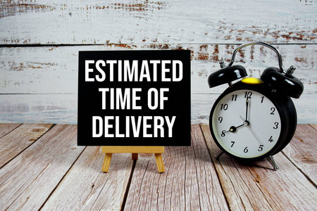 Estimated Time Of Delivery text with easel and alarm clock on wooden background