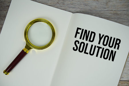 Find Your Solution text message written on paper note with magnifying glass top view on wooden backgroundの写真素材