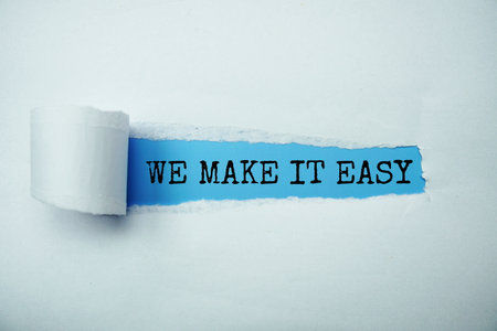 We Make It Easy message written on blue paper with torn paper backgroundの写真素材