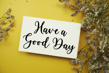 Have a Good Day text with flowers decoration on yellow backgroundの写真素材