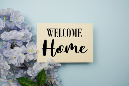 Welcome Home text with flowers decoration on light blue backgroundの写真素材