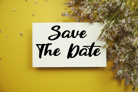 Save The Date text with flowers decoration on yellow backgroundの写真素材