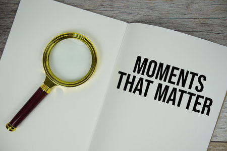Moments That Matter text written on paper with magnifying glass on wooden backgroundの写真素材