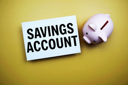 Savings Account text and piggy bank for saving on yellow backgroundの写真素材