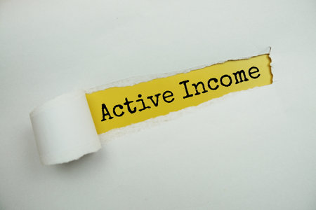 Active Income message written on yellow paper with torn paper backgroundの写真素材