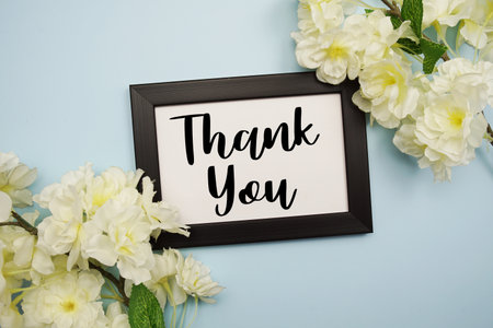 Thank You text with flowers decoration on light blue backgroundの写真素材