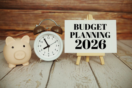 Budget Planning 2026 text message with alarm clock and piggy saving on wooden backgroundの写真素材