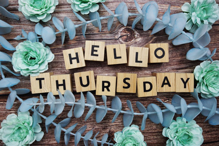 Hello Thursday alphabet letter and flower decorate on wooden backgroundの写真素材
