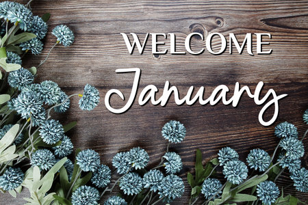 Welcome January text with flowers decoration on wooden backgroundの写真素材