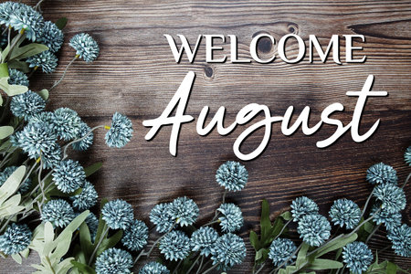 Welcome August text with flowers decoration on wooden backgroundの写真素材